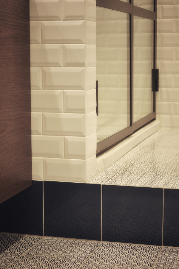 Particolare del bagno con le piastrelle 15x15 in cotto smaltate a mano di Made a Mano, alle pareti le piastrelle di Cesi bianche diamantate 7,5 x 15, che contrastano col legno piallato rovere tinto noce antico scuro e caldo degli arredi.